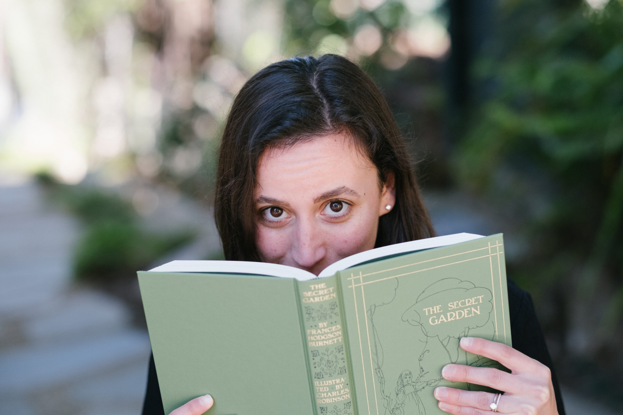 Sasha Bailyn peeking over a book